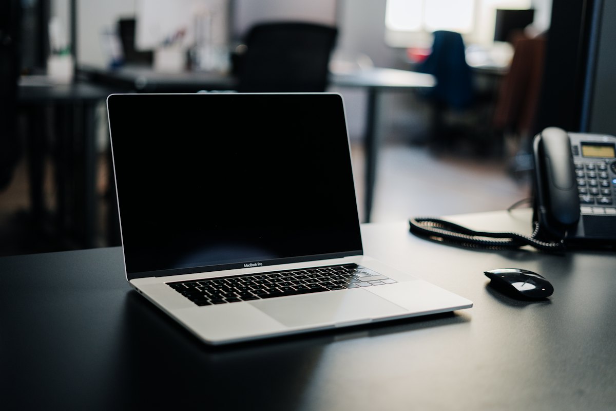 A laptop and a desk phone on a quiet office desk