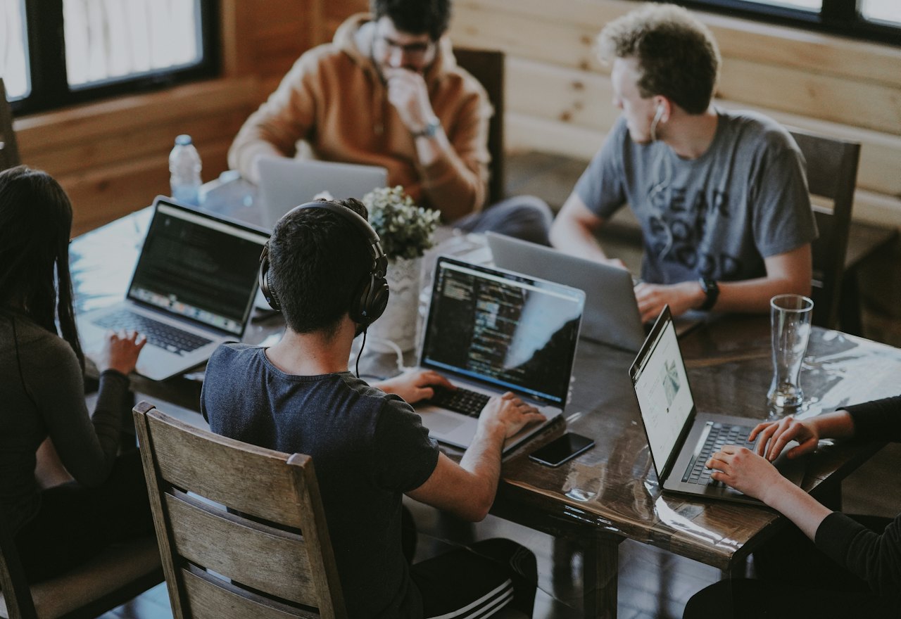 A team working side by side at laptops around one table
