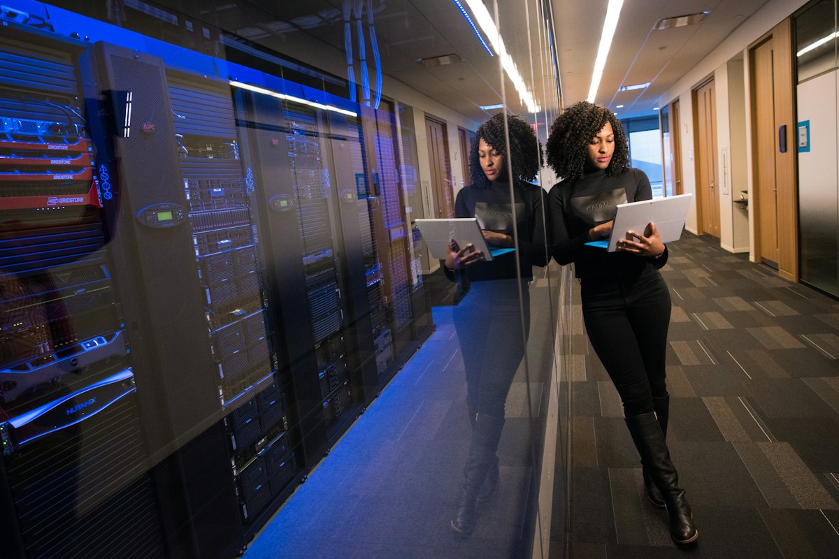 An engineer working beside racks of servers in a data centre aisle