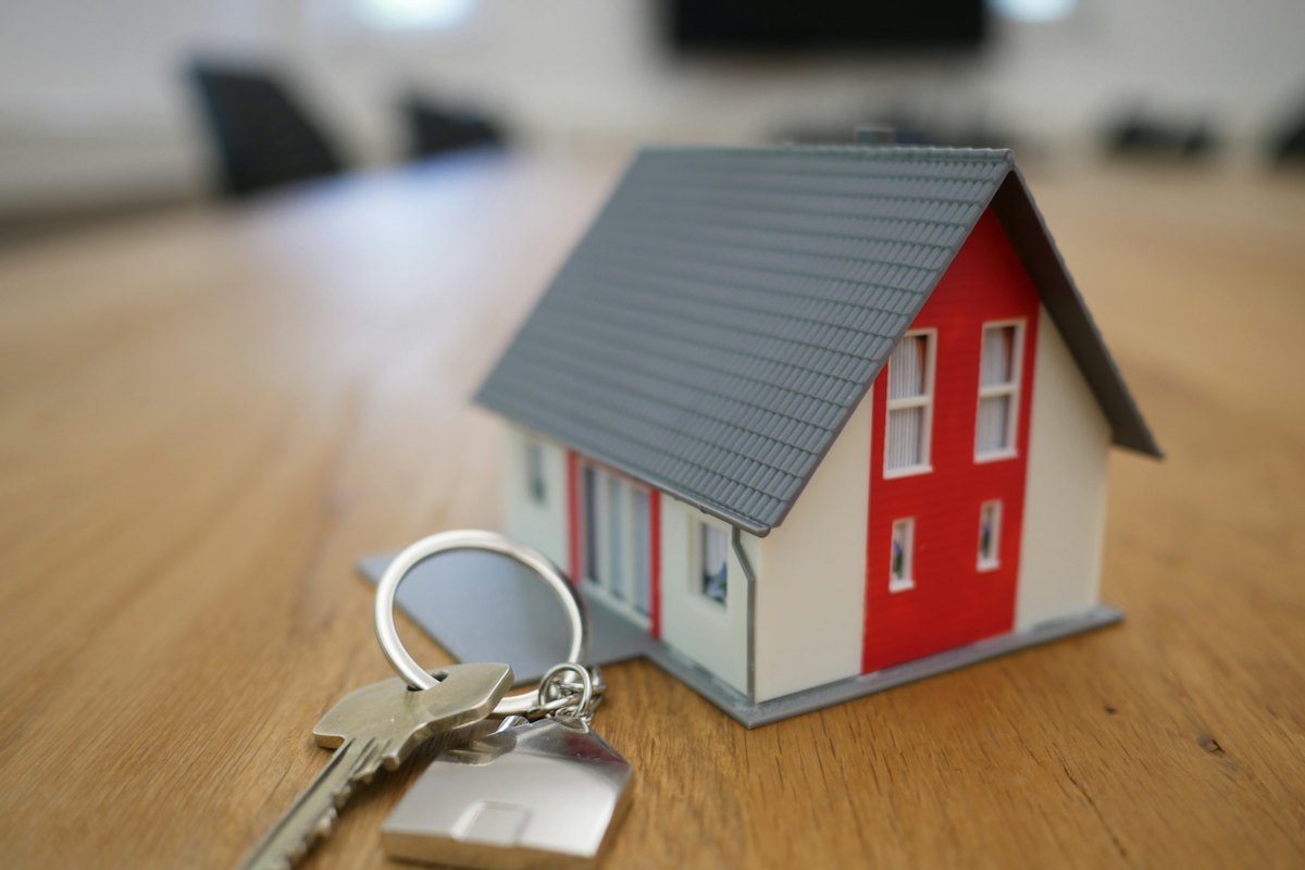 A model house and a set of keys on a wooden table